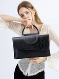 Schwarze, elegante Clutch mit Kroko-Prägung – mit Metallgriff und Schulterriemen